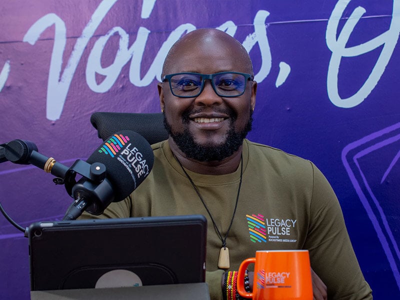 man smiling at camera in front of a mic