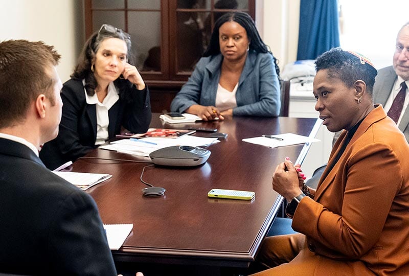 five people seated and speaking around a conference table on Capitol Hill